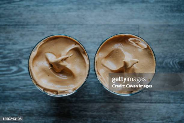 overhead view of whipped coffee on wood table - iced coffee foto e immagini stock