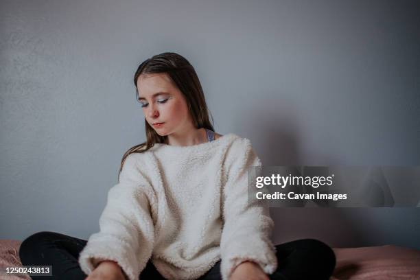 horizontal portrait of tween girl sitting and looking down - adolescent africain stock pictures, royalty-free photos & images
