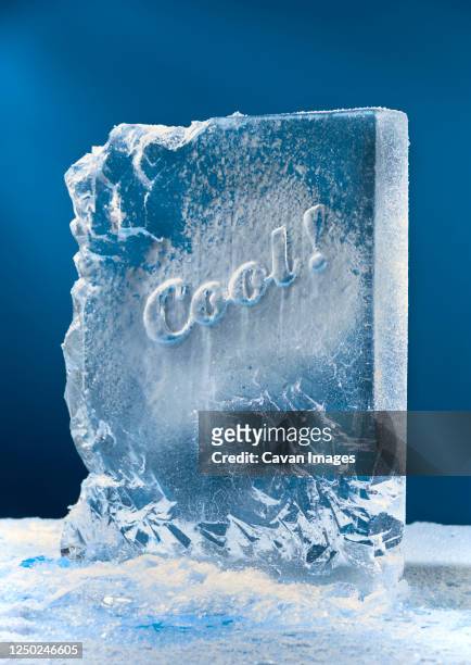 block of ice sculpture with cool carved in it. - ice cube stockfoto's en -beelden
