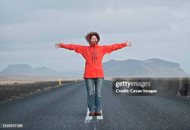 woman standing in the middle of the road with arms stretched out - no meio da estrada - fotografias e filmes do acervo