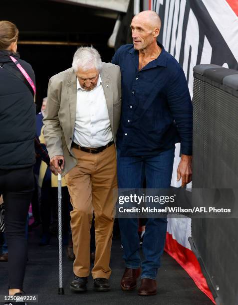 Tony Lockett helps Neil Roberts up the race during the 2023 AFL Round 03 match between the St Kilda Saints and the Essendon Bombers at the Melbourne...