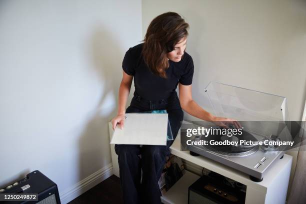 jonge vrouw die verslagen op een draaitafel thuis speelt - personal stereo stockfoto's en -beelden