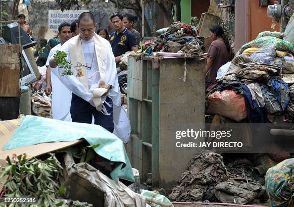Robert Reyes Catholic priest Robert Reyes, wades through mud and uses a tree... News ...