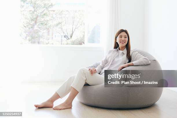 woman lying on sofa - ビーズソファ ストックフォトと画像