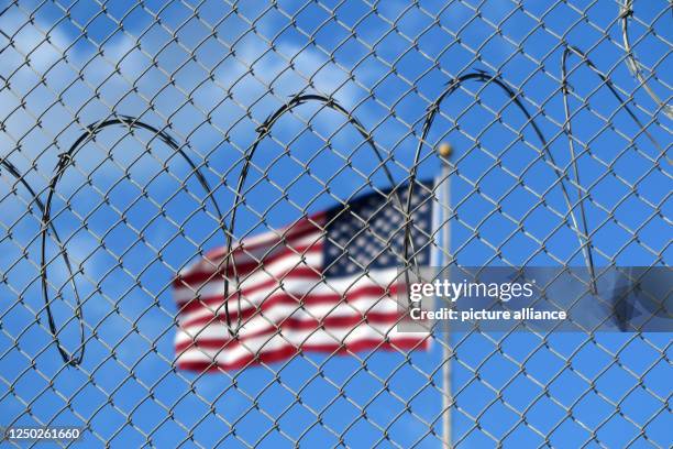 January 2023, Cuba, Guantánamo: A U.S. Flag flies behind barbed wire at the Guantánamo Bay naval base in Cuba. Photo: Magdalena Miriam Tröndle/dpa