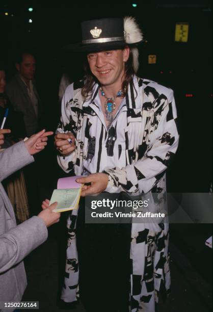 American musician, singer, songwriter, and record producer Stevie Ray Vaughan signing autographs at an event in circa 1990.