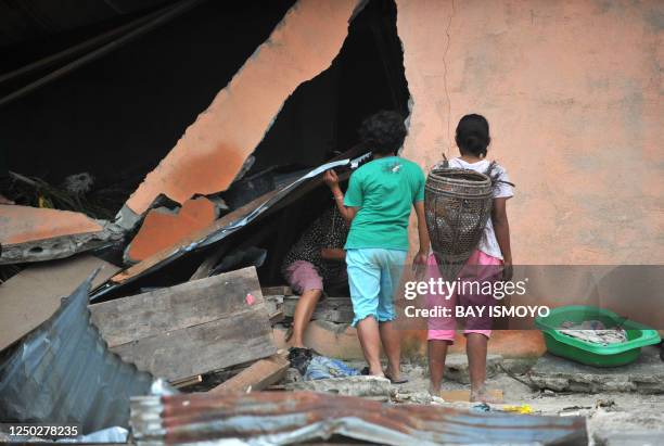 Villagers search for their belongings at a collapse house at Taparaboat village in the Mentawai islands, West Sumatra, on October 28, 2010 after a...