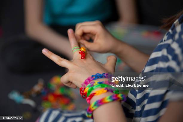 two children crafting with multi coloured elastic bands - bracelet making stock pictures, royalty-free photos & images