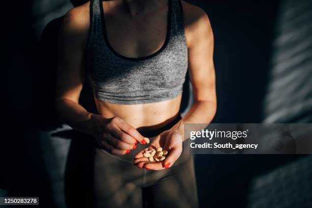 fit frau essen gesunden snack nach dem training in der turnhalle - imbiss stock-fotos und bilder