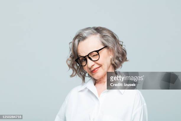 headshot of cheerful senior woman in white shirt - flirting funny stock pictures, royalty-free photos & images