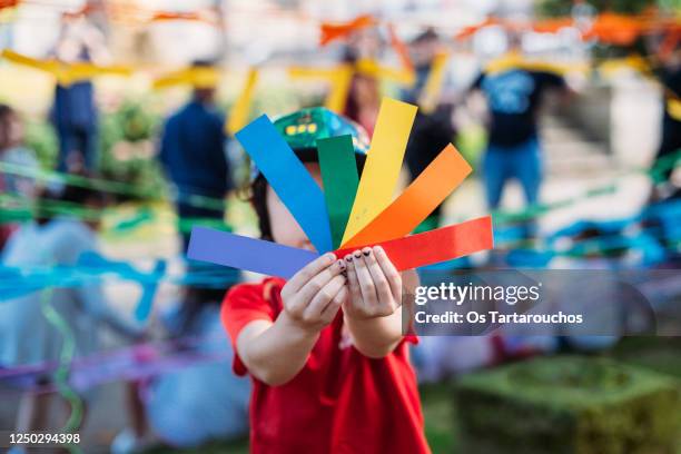 gay pride symbol in kid's hands - rainbow kids stock-fotos und bilder