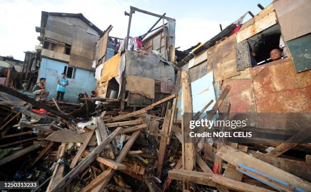 Residents salvage housing materials from a community on Manila Bay in Navotas, part of Metro Manila, on September 29, 2011 in an area that was...