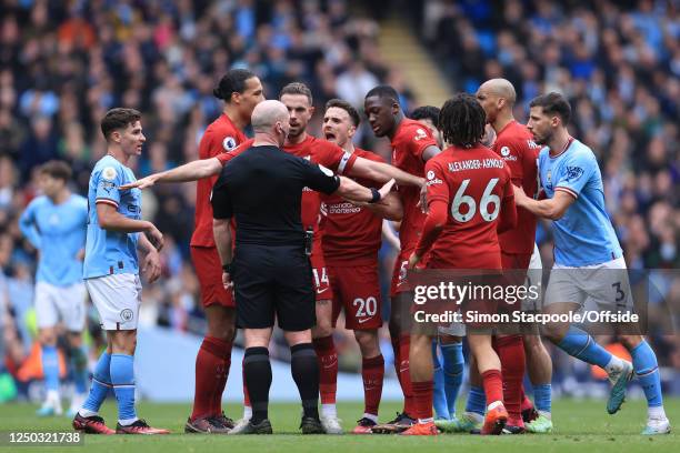 Liverpool players surround referee Simon Hooper and appeal for a second yellow card to be shown to Rodri of Manchester City during the Premier League...