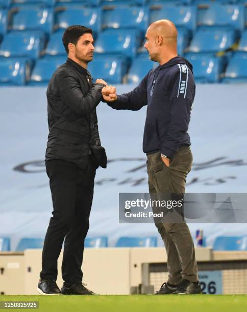 Mikel Arteta, Manager of Arsenal and Pep Guardiola, Manager of Manchester City interact at full-time after the Premier League match between...