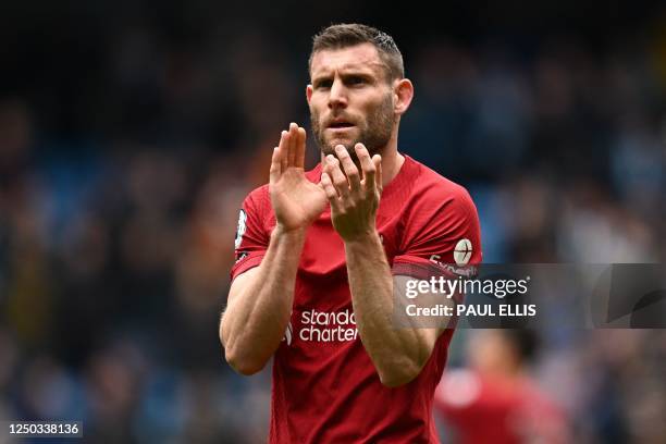 Liverpool's English midfielder James Milner applauds fans on the pitch after the English Premier League football match between Manchester City and...