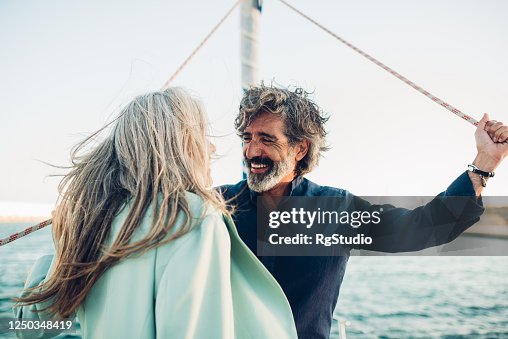 Mature man and his wife enjoying sailing with their yacht Mature man and his wife enjoying sailing with their yacht