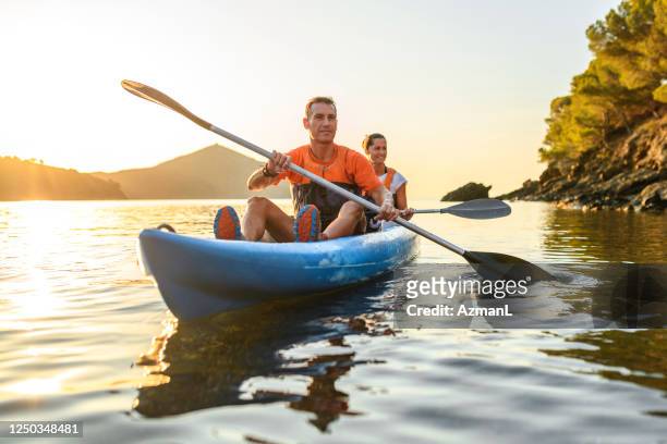 kayakers enjoying healthy lifestyle in mediterranean at dawn - kayak stock pictures, royalty-free photos & images