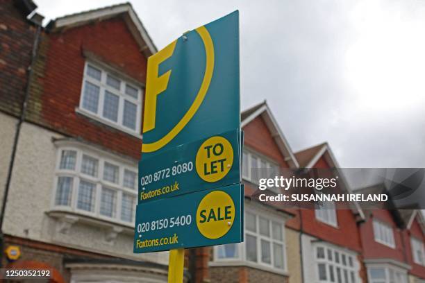 An estate agent board advertising properties to rent and sell is seen outside a row of Edwardian terraced houses in Streatham Hill, in South London,...