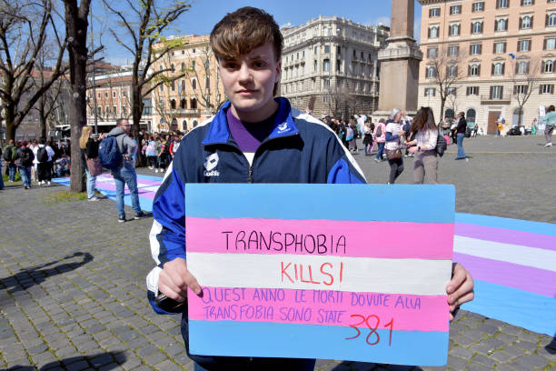 Young trans people participate with placardswritten Transphobia kills and trans flags in the demonstration in the center of Rome for the rights of...