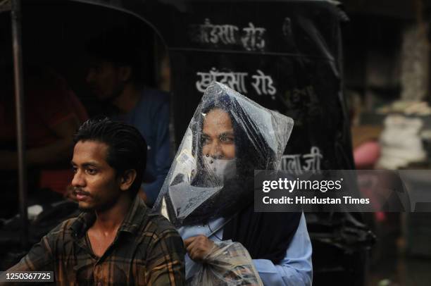 Commuters going to home amid rain showers at Khandsa road near DAV high school, on April 1, 2023 in Gurugram, India.