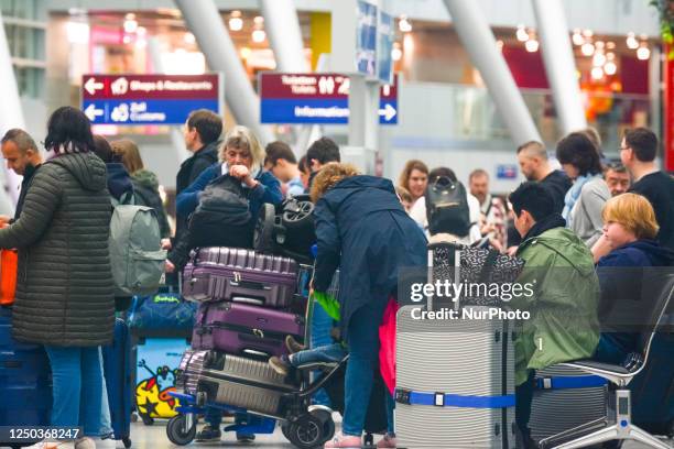 General view of travelers is seen waiting in a long line in front of the Condor Airways check-in counter during the Easter holiday travel time at...