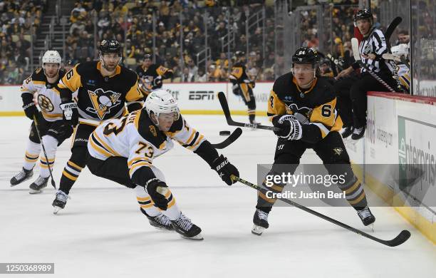 Mikael Granlund of the Pittsburgh Penguins dumps the puck in as Charlie McAvoy of the Boston Bruins defends in the first period during the game at...