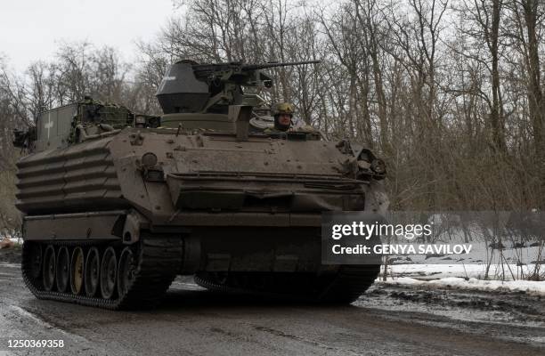 Ukrainian serviceman drives an armoured personnel carrier along a road near the frontline near Bakhmut, Donetsk region, on April 1 amid the Russian...