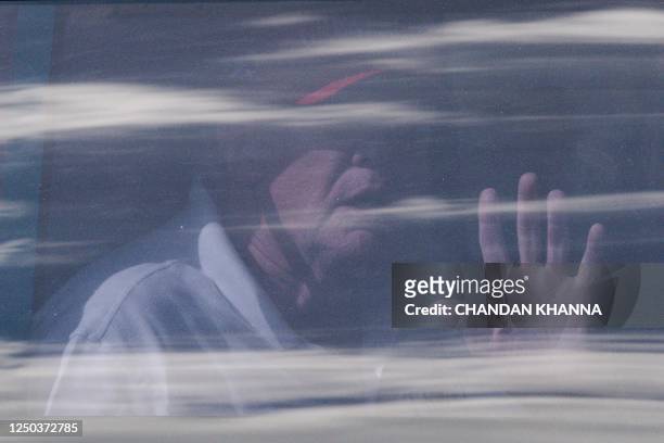 Former US President Donald Trump sits in the rear of his limousine as he departs Trump International Golf Club in West Palm Beach, Florida, on April...