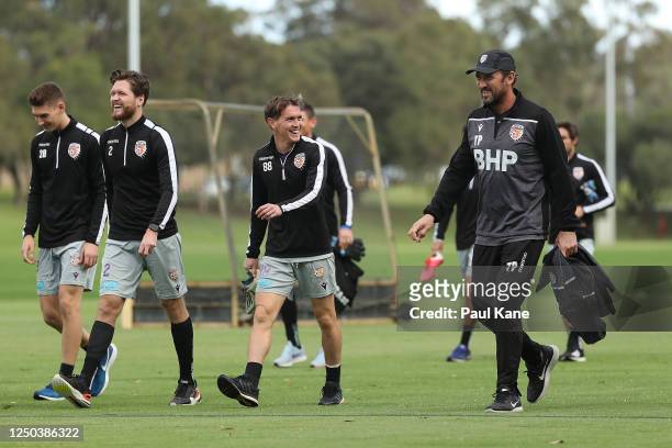 Tony Popovic, head coach of the Glory walks with Gabriel Popovic, Alex Grant and Neil Kilkenny to the training field during a Perth Glory A-League...