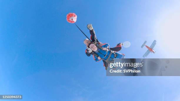 woman with instructor in free fall. - tandem stock pictures, royalty-free photos & images
