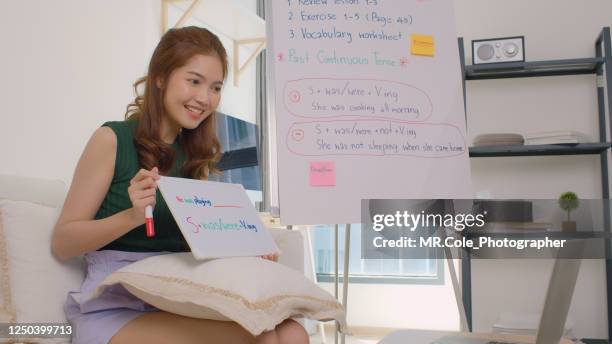 beautiful asian woman teaching english language online at home - english language stock pictures, royalty-free photos & images