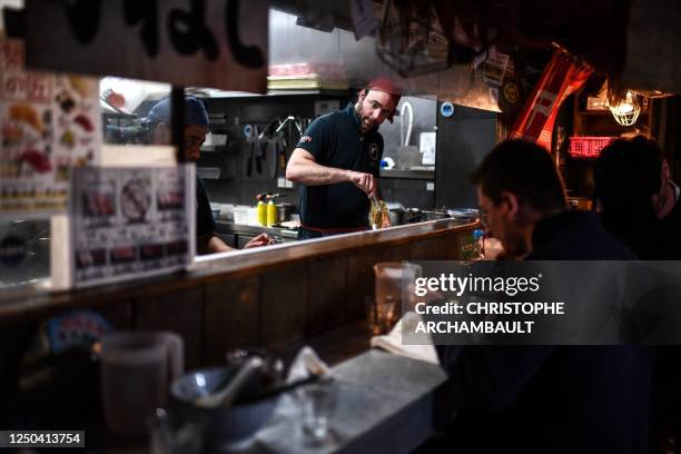 Chef prepares a bowl for customers having a meal at the Kodawari Tsukiji ramen restaurant in Paris on March 31, 2023. - In Paris, long queues appear...