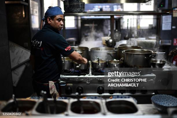 Chef cooks for customers having a meal at the Kodawari Tsukiji ramen restaurant in Paris on March 31, 2023. - In Paris, long queues appear in front...