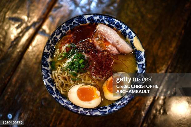 Bowl is ready to be served to customers having a meal at the Kodawari Tsukiji ramen restaurant in Paris on March 31, 2023. - In Paris, long queues...