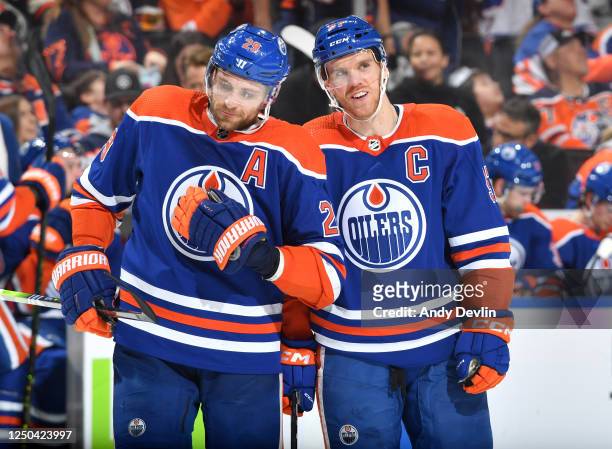 Connor McDavid and Leon Draisaitl of the Edmonton Oilers have a conversation while awaiting a face-off during the game against the Anaheim Ducks on...