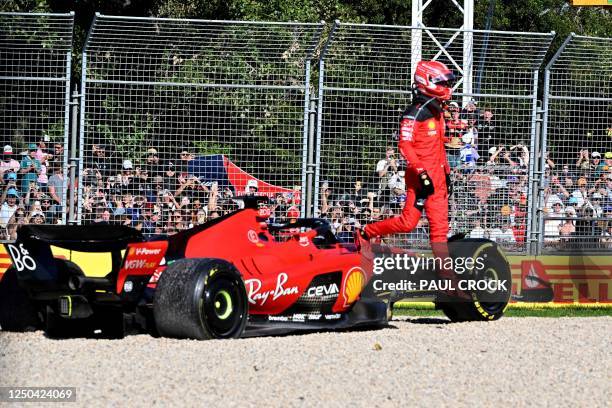 Fans watch as Ferrari's Monegasque driver Charles Leclerc jumps out of the car after a crash during the 2023 Formula One Australian Grand Prix at the...