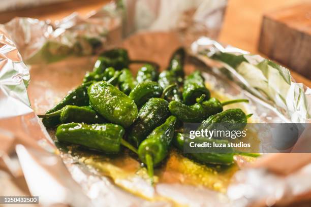 preparing pimientos de padron with salt and olive oil - spain food stock pictures, royalty-free photos & images