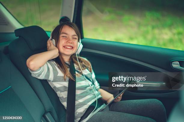 車の旅を楽しませ続ける - girl in car with ipad ストックフォトと画像