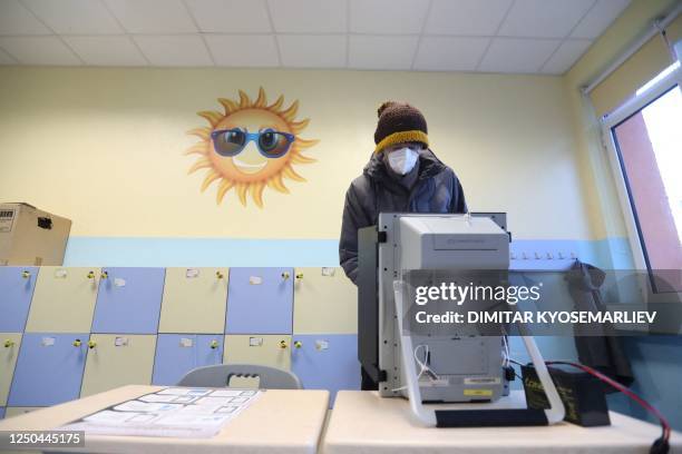 Woman casts her ballot at a polling station during the country's parliamentary elections in Sofia on April 2, 2023. - Bulgarians vote on April 2 in...