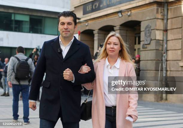 Bulgaria's former prime minister Kiril Petkov and his wife Linda McKenzie walk outside the polling station after casting their ballots during the...