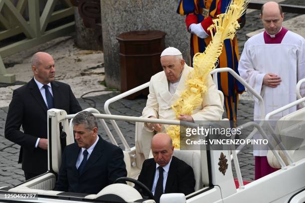 Pope Francis, holding a woven palm branch, sits in the popemobile car during the Palm Sunday mass at St. Peter's square on April 2, 2023 in The...