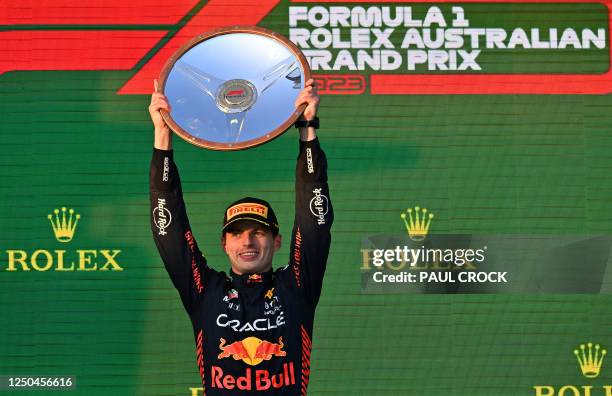 Red Bull Racing's Dutch driver Max Verstappen celebrates with the trophy on the podium after the 2023 Formula One Australian Grand Prix at the Albert...