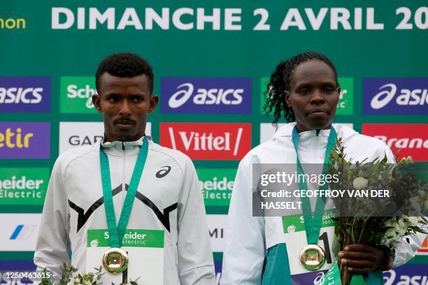 Ethiopia's Abeje Ayana, and Kenya's Helah Kiprop pose with thier winner's medals after coming first in the 2023 Paris Marathon, at the Arc de...