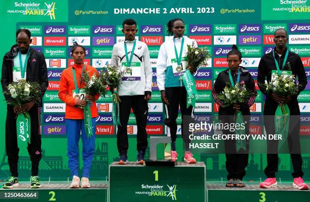 Ethiopia's Abeje Ayana, and Kenya's Helah Kiprop pose on the podium with the second placed and third placed winners in the 2023 Paris Marathon, at...