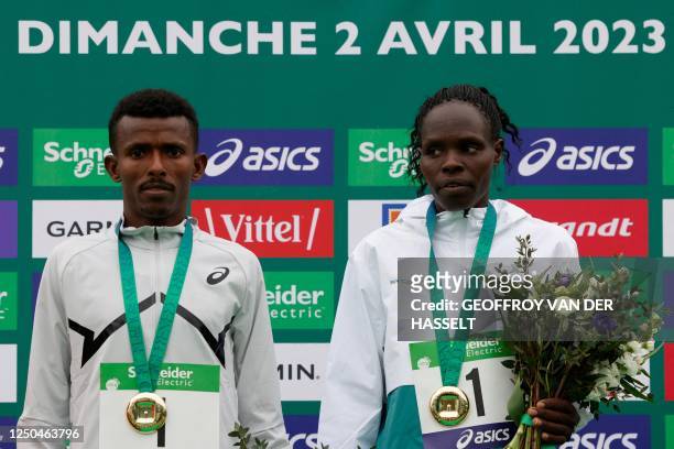Ethiopia's Abeje Ayana, and Kenya's Helah Kiprop pose with thier winner's medals after coming first in the 2023 Paris Marathon, at the Arc de...