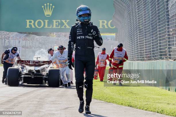 George Russell of Great Britain walks away from of his burning Mercedes AMG Petronas F1 Team F1W14 during the F1 Grand Prix of Australia at Melbourne...