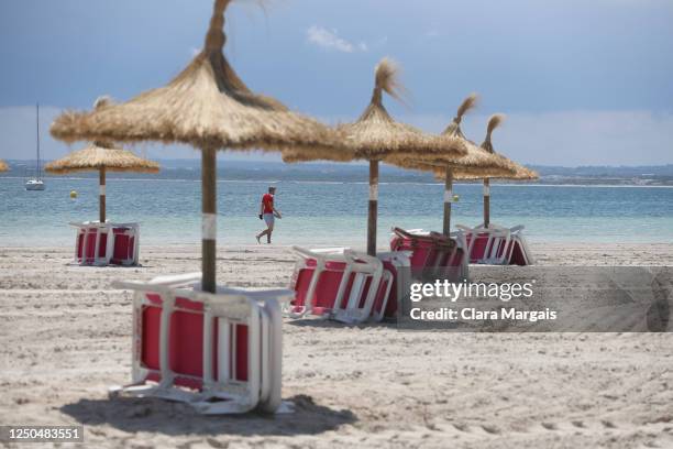 Tourist walks on Alcudia beach on June 18, 2020 in Alcudia, Mallorca, Spain. From June 15, approximately 10,900 holidaymakers from Germany are...