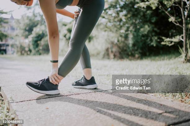 an asian chinese female teenager girl exercising jogging in the public park in the morning with sport clothing - leg stretch girl stock pictures, royalty-free photos & images