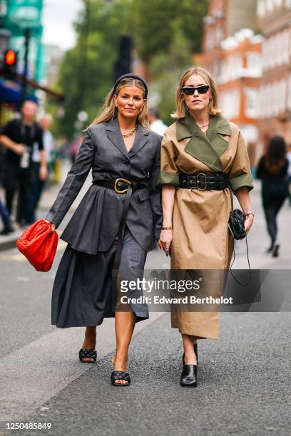 Guest wears a headband, a gray oversized blazer jacket, a belt, a skirt, quilted black shoes, a chain necklace ; a guest wears sunglasses, a brown...