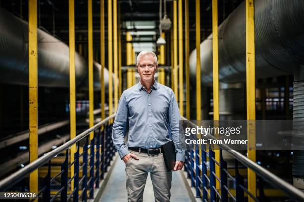 portrait of senior printery manager on walkway - industrie und mensch stock-fotos und bilder